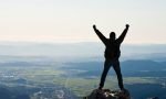 Happy mountaineer standing on the top