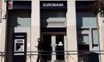 A man walks outside a Eurobank branch in Athens