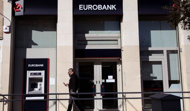 A man walks outside a Eurobank branch in Athens
